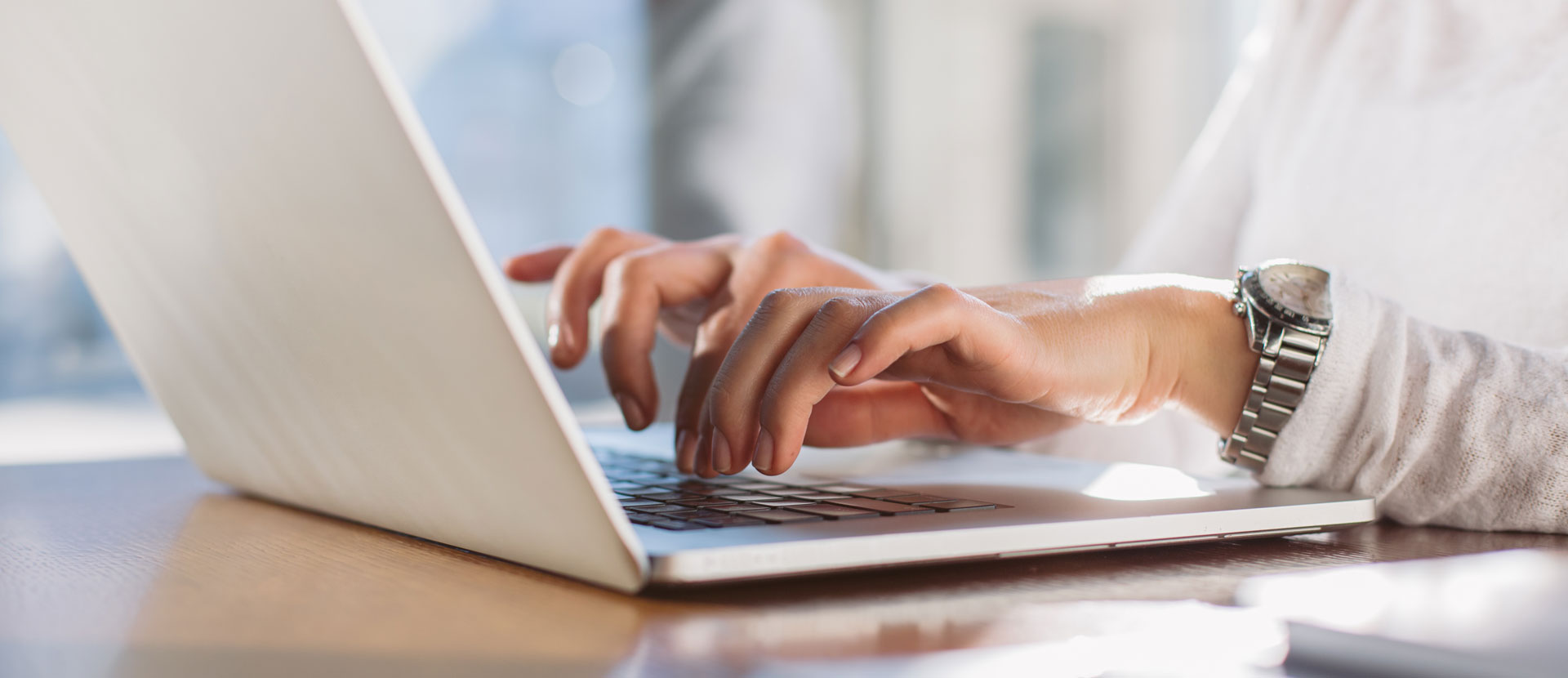 Hände tippen auf Laptop Tastatur