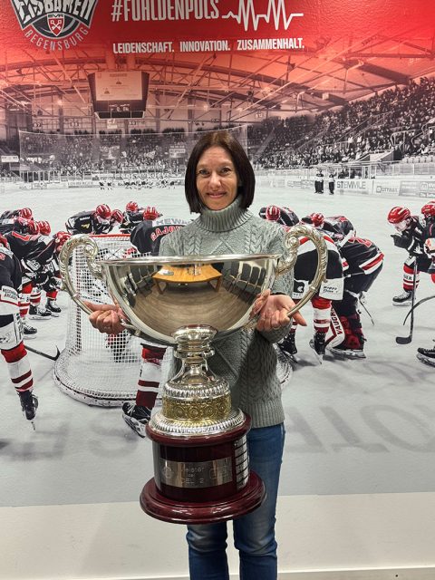 Frau hält einen Pokal der Eisbären Regensburg